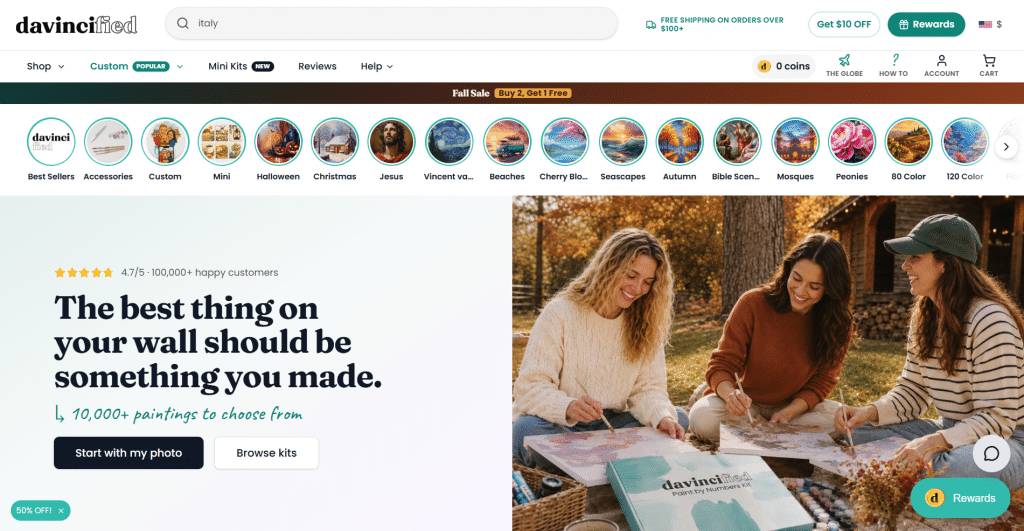 Light hero section for Davincified titled "The best thing on your wall should be something you made.", featuring a top search bar, category stories carousel, call-to-action buttons, and a lifestyle photo of three women painting outdoors.